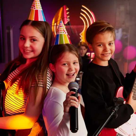Kids at a party playing with musical instruments